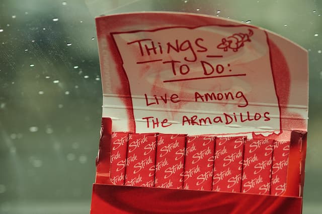 A handwritten Things to Do note on a gum packet: Live among the armadillos.